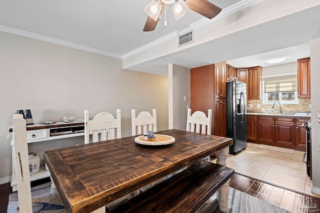 dining room with ornamental molding, sink, and ceiling fan