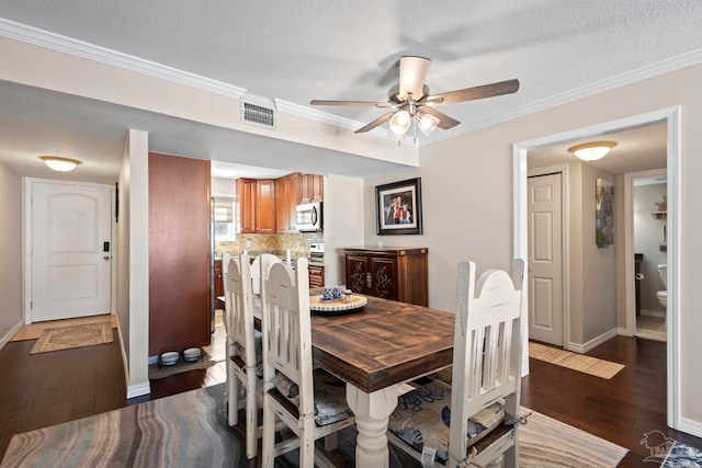 dining room with dark hardwood / wood-style flooring, crown molding, a textured ceiling, and ceiling fan