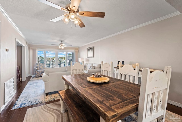 dining space featuring dark hardwood / wood-style flooring, crown molding, and a textured ceiling