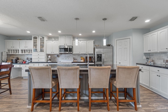 2215 Seascale Ct, Navarre, FL 32566 - kitchen featuring appliances with stainless steel finishes, tasteful backsplash, a breakfast bar, dark countertops, and recessed lighting