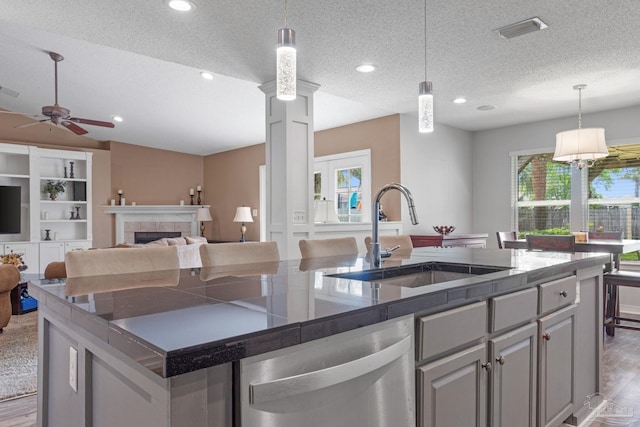 2215 Seascale Ct, Navarre, FL 32566 - kitchen featuring a sink, dishwasher, wood finished floors, a textured ceiling, and hanging light fixtures