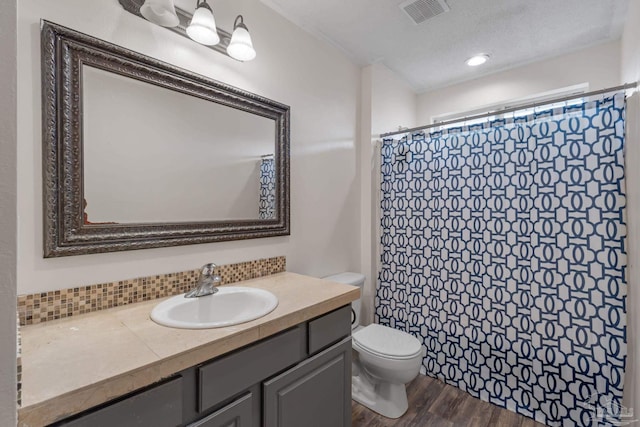 2215 Seascale Ct, Navarre, FL 32566 - full bathroom with vanity, toilet, wood finished floors, a shower with shower curtain, and decorative backsplash