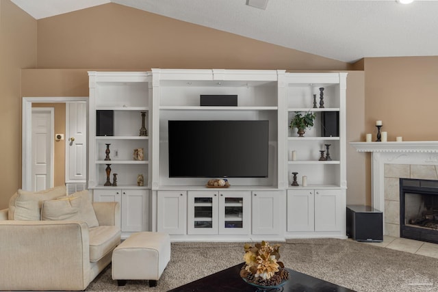 2215 Seascale Ct, Navarre, FL 32566 - living room featuring vaulted ceiling, a tiled fireplace, and light tile patterned floors