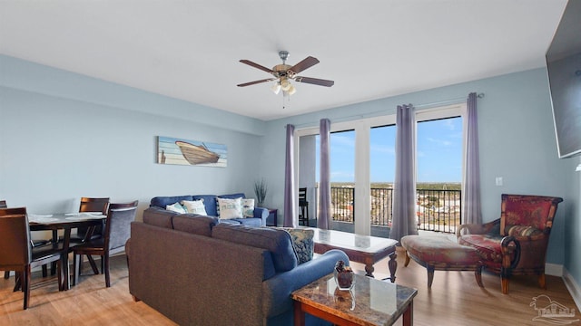 living room with ceiling fan and light hardwood / wood-style flooring