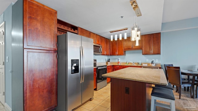 kitchen with pendant lighting, sink, a kitchen island, stainless steel appliances, and a breakfast bar