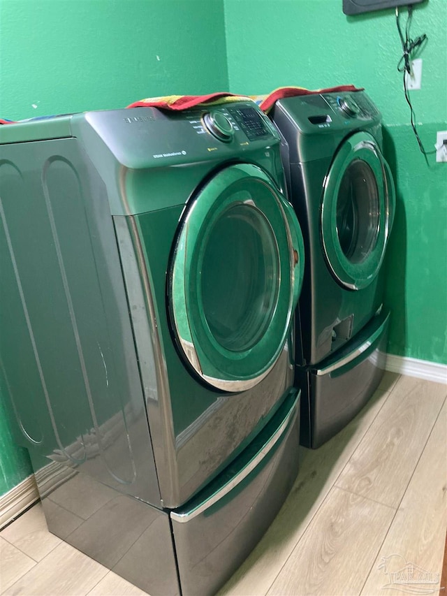 laundry area featuring washer and dryer and light tile patterned floors