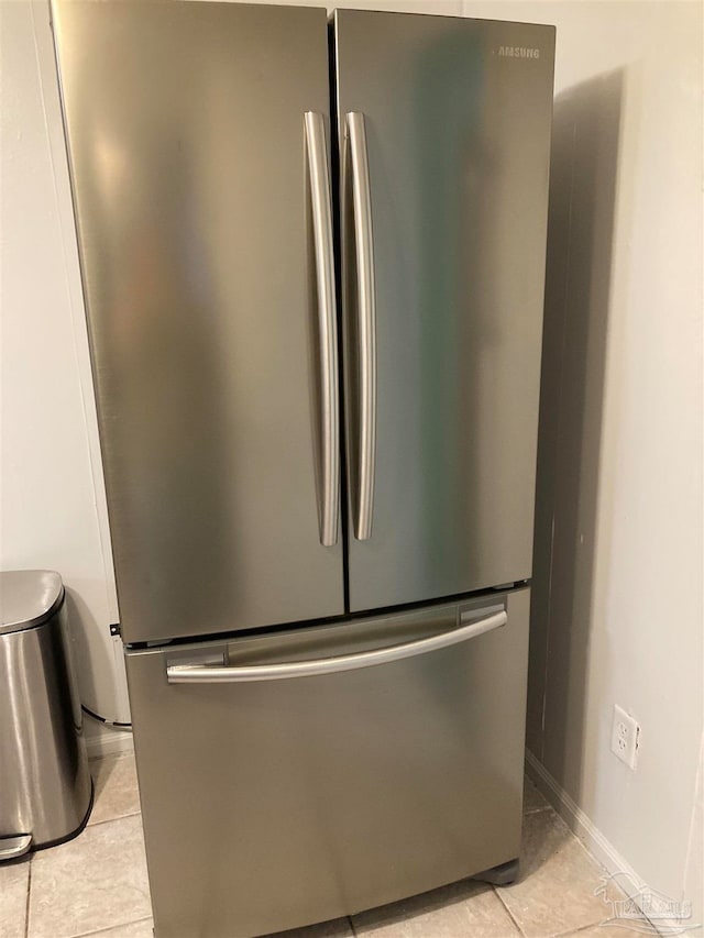 room details featuring stainless steel refrigerator and light tile patterned floors