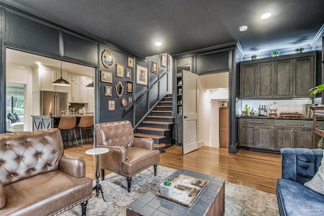 living room featuring light wood-type flooring and crown molding