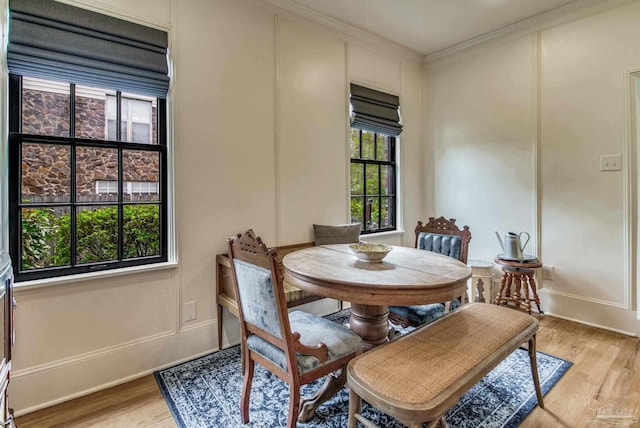 dining room with light hardwood / wood-style floors and ornamental molding