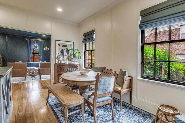 dining space featuring hardwood / wood-style floors and crown molding