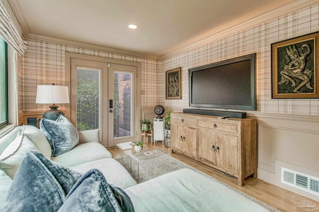 living room featuring crown molding, french doors, and light hardwood / wood-style floors