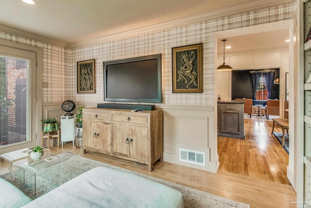 living room with light hardwood / wood-style flooring and ornamental molding