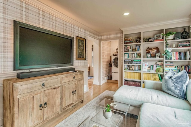 living room featuring washer / clothes dryer, light hardwood / wood-style flooring, and ornamental molding