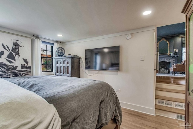 bedroom featuring a fireplace and hardwood / wood-style floors