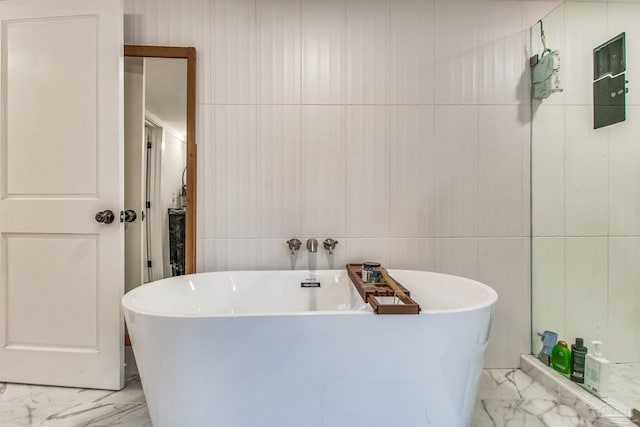 bathroom featuring a bath and tile walls