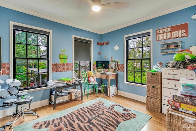 recreation room featuring ceiling fan, light hardwood / wood-style flooring, and crown molding