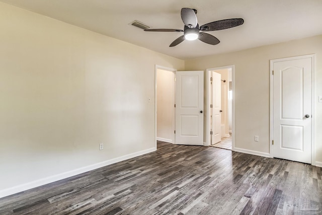 unfurnished bedroom featuring ensuite bathroom, dark wood-type flooring, and ceiling fan