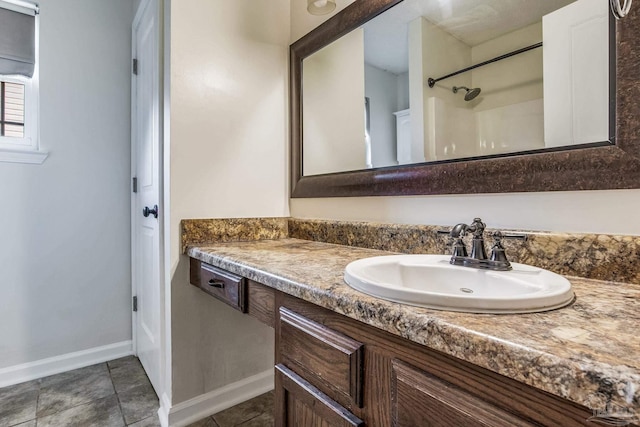 bathroom with tile patterned flooring, vanity, and walk in shower