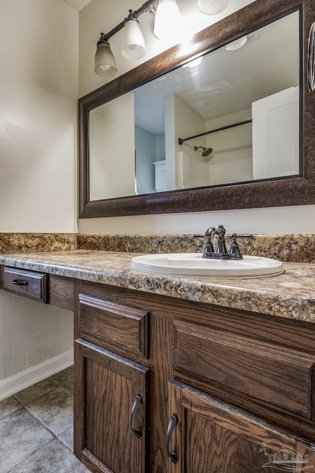 bathroom featuring vanity, tile patterned flooring, and a shower