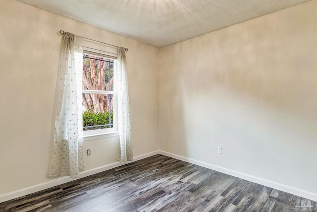 empty room featuring dark hardwood / wood-style floors and a textured ceiling