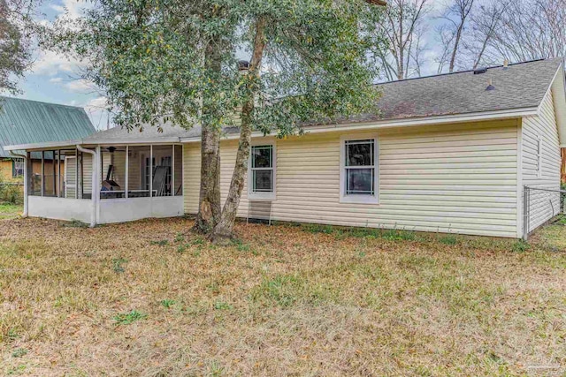 back of property with a yard and a sunroom