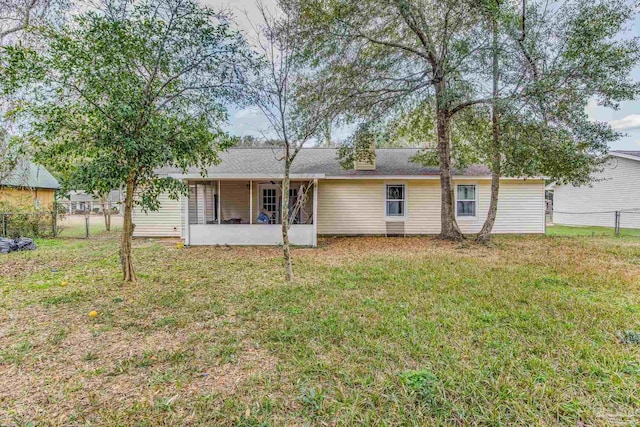 back of house with a sunroom and a lawn