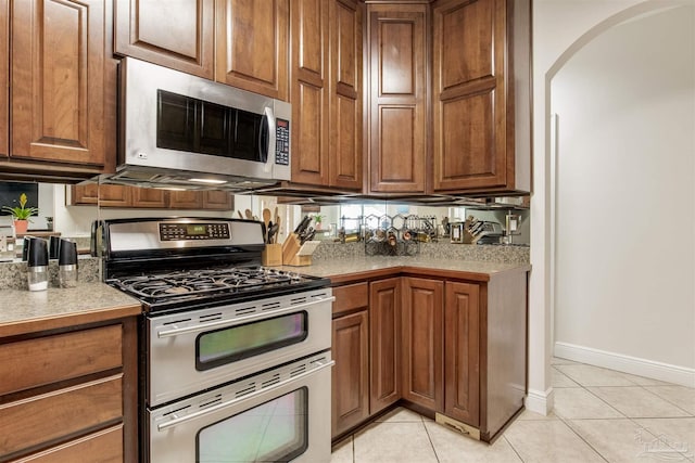 kitchen featuring stainless steel appliances and light tile patterned flooring