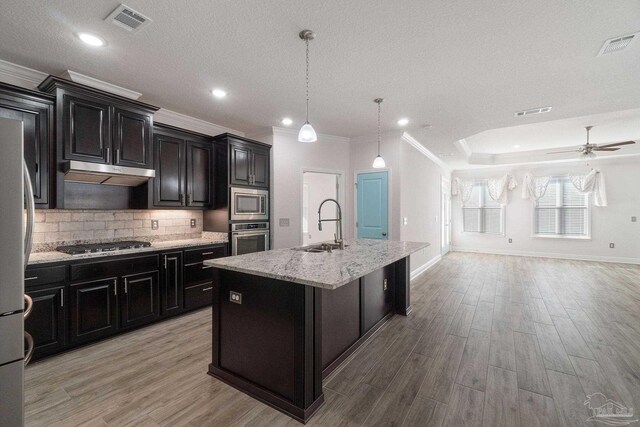 2339 Habersham Ln, Cantonment, FL 32533 - kitchen with stainless steel appliances, open floor plan, a kitchen island with sink, a sink, and under cabinet range hood