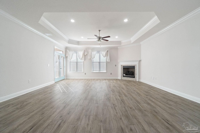2339 Habersham Ln, Cantonment, FL 32533 - unfurnished living room with dark wood-style flooring, a fireplace, baseboards, a tray ceiling, and crown molding