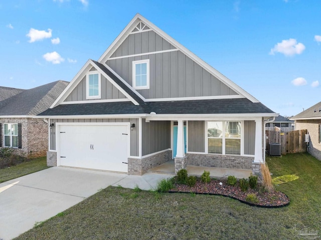 craftsman house with driveway, central AC unit, board and batten siding, and a front lawn