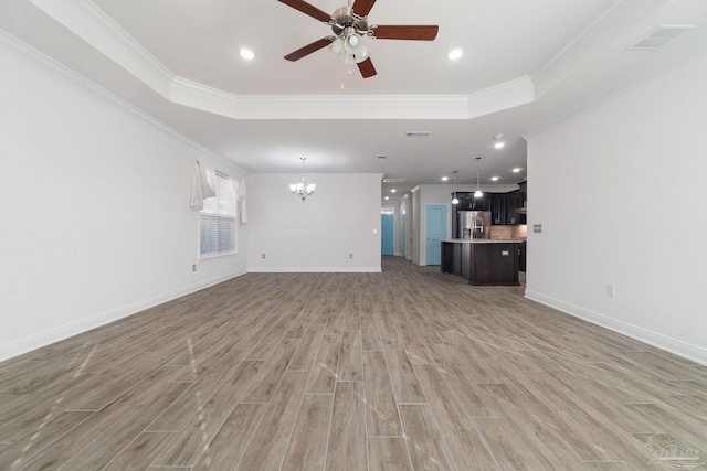 2339 Habersham Ln, Cantonment, FL 32533 - unfurnished living room featuring baseboards, a tray ceiling, light wood-type flooring, and crown molding