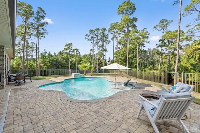 view of swimming pool with a patio, pool water feature, and an outdoor fire pit