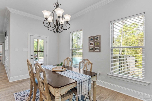 dining area featuring light hardwood / wood-style flooring, ornamental molding, and a chandelier