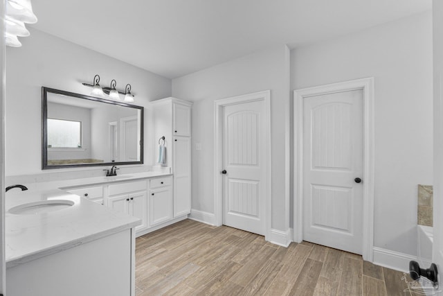 bathroom with vanity, hardwood / wood-style floors, and a bathing tub