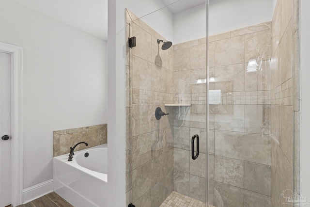 bathroom with hardwood / wood-style flooring and shower with separate bathtub