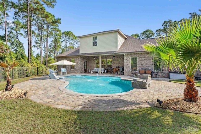 view of swimming pool featuring a yard, pool water feature, and a patio area