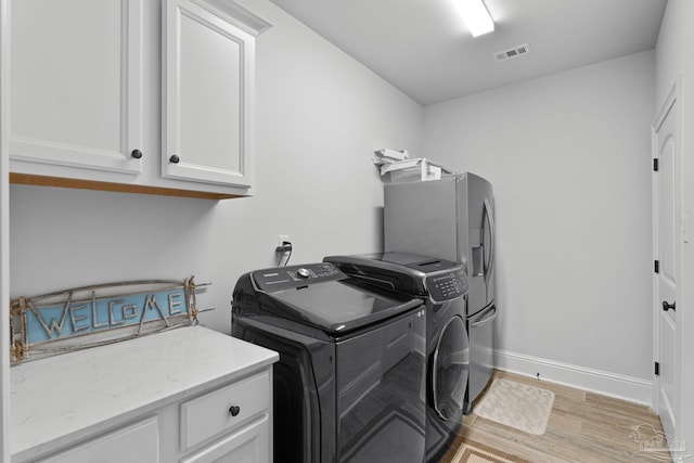 4726 Soundside Dr, Gulf Breeze, FL 32563 - washroom with cabinet space, light wood-style floors, washer and clothes dryer, and baseboards