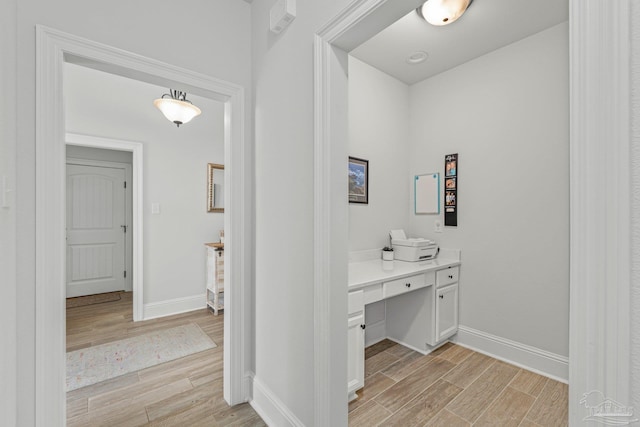 4726 Soundside Dr, Gulf Breeze, FL 32563 - hall featuring light wood-type flooring, baseboards, and a desk