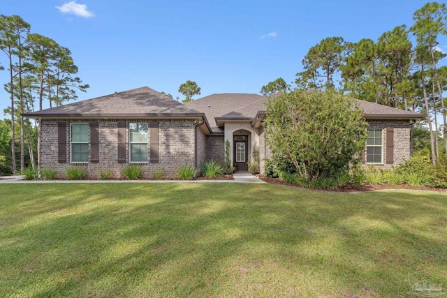 4726 Soundside Dr, Gulf Breeze, FL 32563 - view of front of house featuring a front yard, brick siding, and a shingled roof