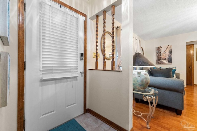 entryway with wood-type flooring and a textured ceiling