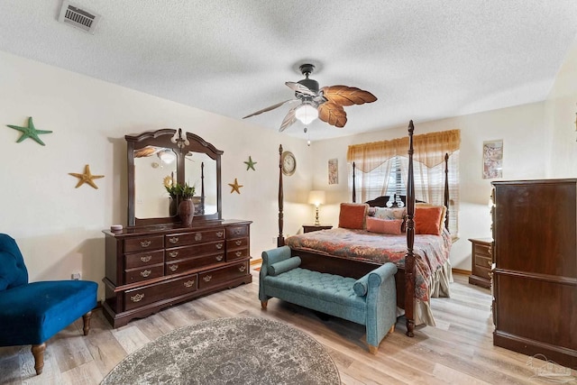 bedroom featuring ceiling fan, a textured ceiling, and light wood-type flooring