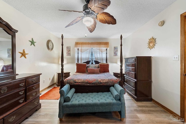 bedroom featuring a textured ceiling, light wood-type flooring, and ceiling fan