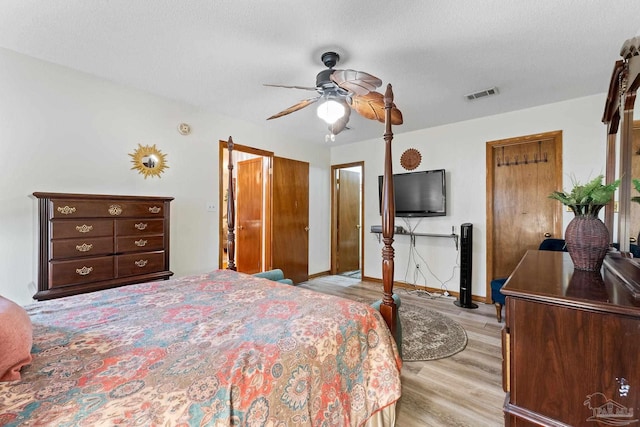 bedroom with ceiling fan, a textured ceiling, and light hardwood / wood-style flooring