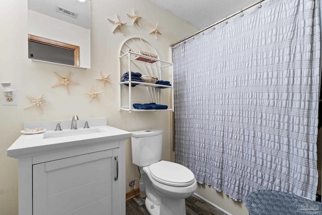 full bathroom with wood-type flooring, a textured ceiling, toilet, vanity, and shower / tub combo