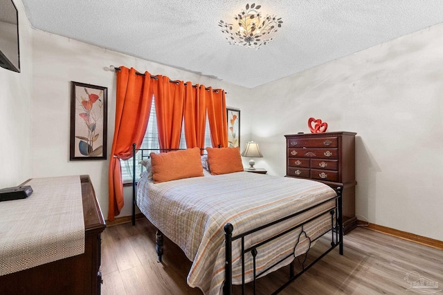 bedroom with hardwood / wood-style flooring and a textured ceiling