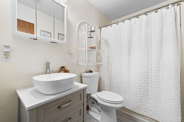 bathroom with a textured ceiling, toilet, hardwood / wood-style flooring, vanity, and a shower with shower curtain