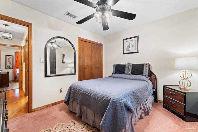 carpeted bedroom with ceiling fan, a textured ceiling, and a closet