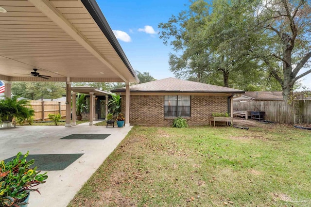 view of yard with ceiling fan and a patio area