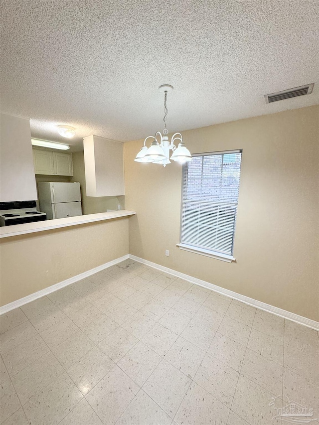 unfurnished dining area with a textured ceiling and a notable chandelier