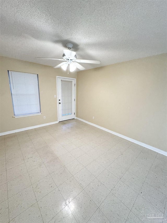 empty room with a textured ceiling and ceiling fan